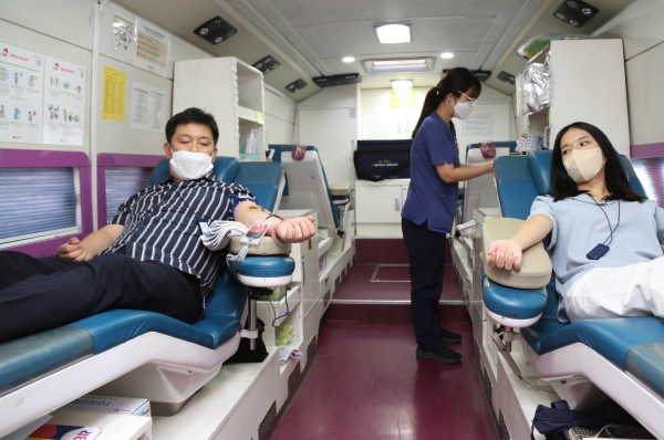 DL그룹 임직원들이 돈의문 디타워에 출장한 헌혈 버스에서 헌혈을 하고 있다.(제공 DL그룹)